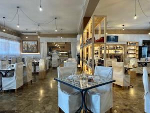 a restaurant with white chairs and a table with glasses on it at Asso di Coppe in Deruta
