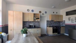 a kitchen with wooden cabinets and a table with a potted plant at Rhin Quartier Ferienwohnung Hostel-Style in Rheinsberg