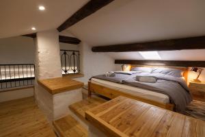 a bedroom with a king sized bed and wooden floors at Campanile Nero in Prata Camportaccio