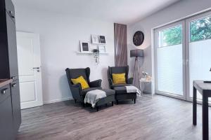 a living room with two chairs and a window at Emsland Hus WG2 in Niederlangen