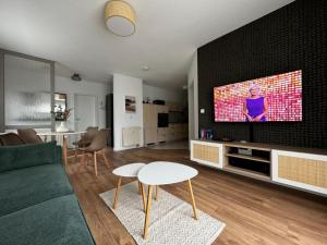 a living room with a couch and a flat screen tv at Ferienwohnung "Zur Amsel" in Burkhardtsdorf