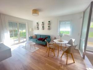 a living room with a blue couch and a table and chairs at Ferienwohnung "Zur Amsel" in Burkhardtsdorf