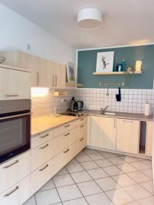 a kitchen with white cabinets and a blue wall at Ferienwohnung "Zur Amsel" in Burkhardtsdorf