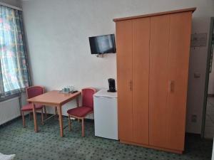 a room with a table and a cabinet and a table and chairs at Mariazellerhof Room 018 in Sankt Pölten