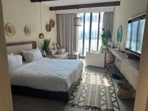 a hotel room with a bed and a television at Le sidi Luxury Hotel Cabana Hacienda bay in El Alamein