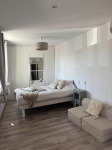 a bedroom with a bed and a couch and a mirror at Maison avec Sauna Saint-Valery-sur-Somme in Saint-Valery-sur-Somme