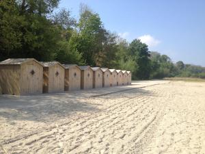 a row of wooden huts on the side of a beach at Maison avec Sauna Saint-Valery-sur-Somme in Saint-Valery-sur-Somme +15 photos