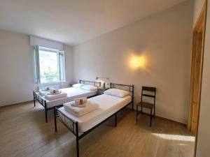 a room with two beds and a window at Rifugio Casa Cantoniera in Marsaglia