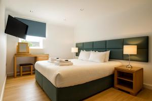 Un dormitorio con una cama grande con cabecero verde. en Edinburgh Aparthotel, en Edimburgo