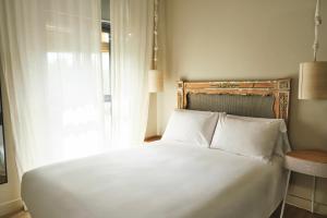a bedroom with a white bed and a window at The Corner House in Seville