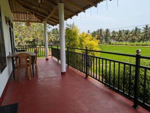 a balcony of a house with a table and chairs at Bird Nest Guest House in Lukasgoda