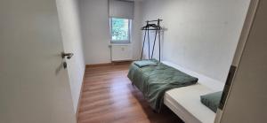 Un dormitorio con una cama en una habitación con ventana. en Apartment in Vaihingen an der Enz - Ensingen, en Vaihingen an der Enz 9 fotos más