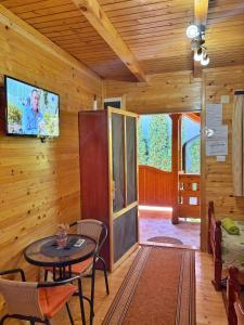 a living room with a table and a tv on a wall at Eko Apartmani in Bački Petrovac