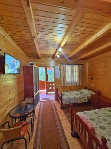 a room with two beds and a table in a cabin at Eko Apartmani in Bački Petrovac
