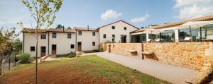 a house with a stone wall and a fence at Agriturismo Castel Bricon in Lonigo