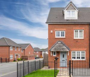 una casa de ladrillo con una valla delante en 4 Bedroom House In Manchester, en Mánchester
