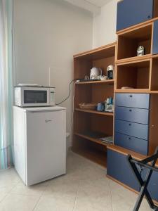 a kitchen with a microwave on top of a refrigerator at Il Violoncello in Torre Nubia