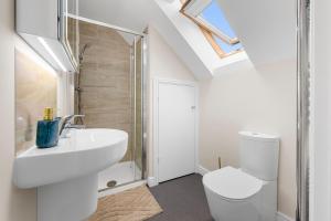 Un baño blanco con lavabo e inodoro. en 4 Bedroom House In Manchester, en Mánchester 14 fotos más