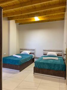 two beds sitting next to each other in a room at Luxor Thames apartment in Luxor