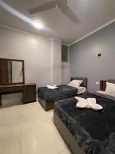 a hotel room with two beds and a mirror at Luxor Thames apartment in Luxor +21 photos