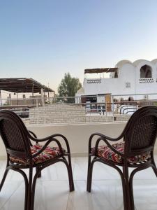 two chairs sitting in front of a baseball stadium at Luxor Thames apartment in Luxor