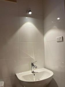 a bathroom with a sink and a light on the wall at Luxor Thames apartment in Luxor