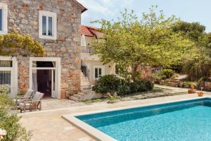 an external view of a house with a swimming pool at Villa Estelle, Hvar Island in Vrbanj +71 photos