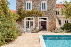 a house with a swimming pool in front of it at Villa Estelle, Hvar Island in Vrbanj