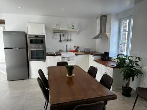 a kitchen with a wooden table and a dining room at Gîte de Gondelot in Augers-en-Brie