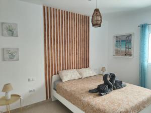 ein Schlafzimmer mit einem Bett mit einem hölzernen Kopfteil in der Unterkunft Villa Estrella de Blanca in La Oliva