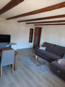 a living room with a couch and a table at Appartement confortable avec terrasse in Zweisimmen
