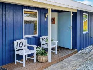 Neder LysabildにあるCozy Retreat in Skovmoseの青い家の玄関に座る椅子2脚