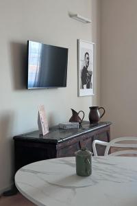 ein Raum mit einem Tisch und einem Fernseher an der Wand in der Unterkunft Suite del Campione in Asti