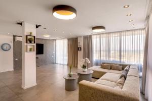 a large living room with a couch and a tv at לה כינרה - ווילה מדהימה עם בריכה פרטית מחוממת ונוף לכנרת במגדל in Migdal +15 photos