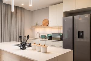 a kitchen with a counter with a refrigerator at Zimbali Luxury Garden Villa in Ballito +7 photos