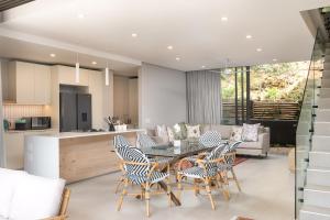 a kitchen and living room with a table and chairs at Zimbali Luxury Garden Villa in Ballito