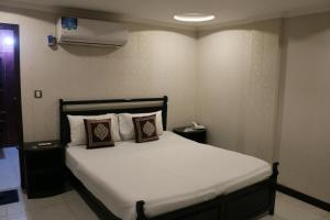 a bedroom with a bed with two pillows on it at Hotel Airport View in Lahore