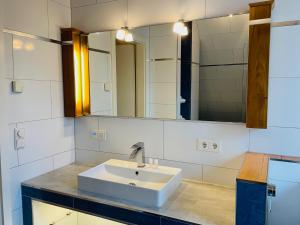 a bathroom with a sink and a mirror at Weingärtner Appartements in Mannheim +39 photos