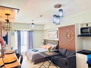 une chambre avec un lit, un canapé et une table dans l'établissement Avida Towers Riala T3 Tunechi, à Cebu