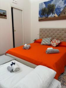 2 camas en un dormitorio con naranja y blanco en Appartamento Frisa del Salento Room in centro storico Mesagne, en Mesagne