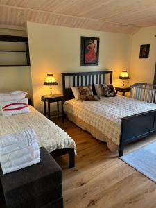 a bedroom with two beds and two tables and lamps at Muhu Kulla Saadu puhkemaja mere ääres in Raugi