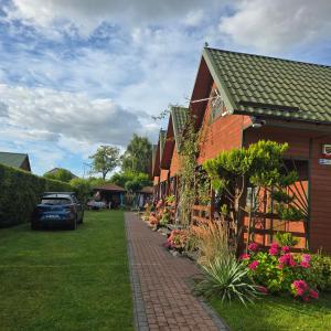 una acera de ladrillo junto a una casa con flores en Makowe Domki, en Władysławowo