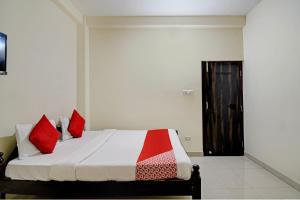 布巴内什瓦尔Hotel O Swiss stay的一间卧室，床上有红色枕头