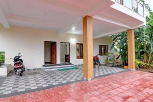 布巴内什瓦尔Hotel O Swiss stay的停在庭院的房屋,有一辆摩托车