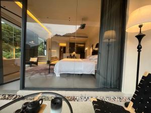 um quarto com vista para um quarto através de um espelho em Nature Eco Designer Hotel--Avatar mountain view,Bubble Pool,Free shuttle to south gate of Park Entrance,Local trip plan & Tourism Service,Full Renovation for 10 months em Zhangjiajie