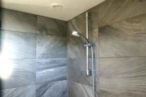 a shower in a bathroom with a stone wall at Le Trèfle de l'Impériale-Les gites de l imperiale in Sermizelles +30 photos