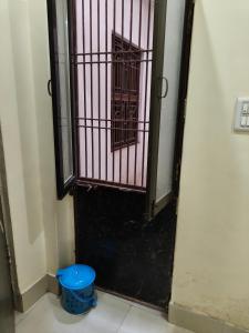 Una puerta abierta con un cubo azul delante de ella. en The Island chfe, en Varanasi