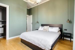 una camera da letto con un letto grande con lenzuola bianche di Design & Dine a Milano