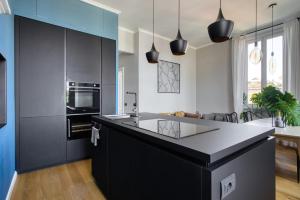 una cucina con armadi neri e un'isola nera di Design & Dine a Milano