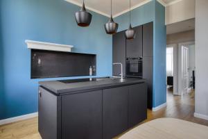 una cucina con armadi neri e parete blu di Design & Dine a Milano Altre 22 foto